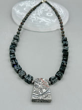 Load image into Gallery viewer, This rustic necklace features an eye-catching large trapezoid-shaped Picasso jasper, hematite, square-shaped snowflake obsidian combo set in a unique and chic design. Handcrafted from genuine stones, this necklace is perfect for any bohemian look.   Measurements:  Necklace is 21&quot;
