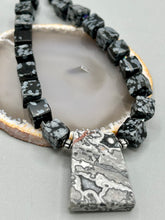 Load image into Gallery viewer, This rustic necklace features an eye-catching large trapezoid-shaped Picasso jasper, hematite, square-shaped snowflake obsidian combo set in a unique and chic design. Handcrafted from genuine stones, this necklace is perfect for any bohemian look.   Measurements:  Necklace is 21&quot;
