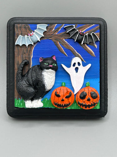 This handcrafted Halloween theme polymer clay wall art boasts a square-shaped wood frame with hand sculpted tuxedo cat, gray and black bats, jack-o-lantern and ghost motifs. Its cool sky hues, including light to dark blues are further complemented by the black frame adding an extra layer of sophistication to the spooky cool-toned artwork.  Measurements: H 4