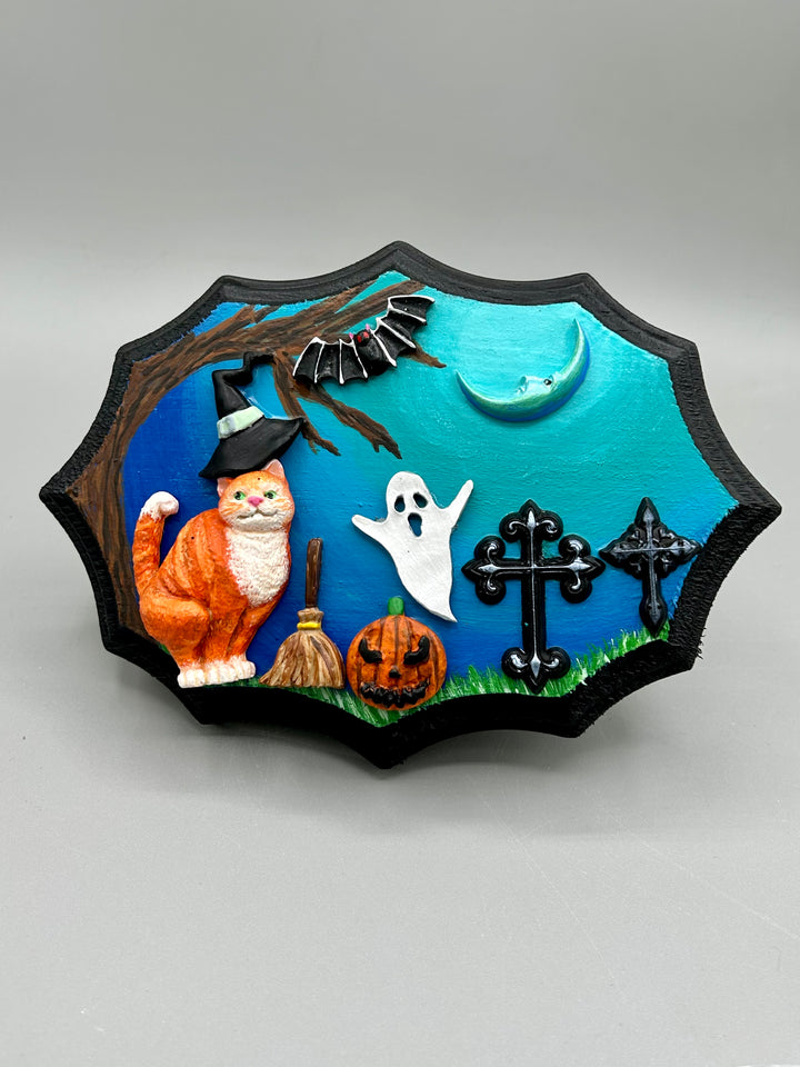 Handcrafted Halloween polymer clay wall art on a wood frame with cats, bats, jack-o-lantern and ghosts motifs. A spooky fun hand sculpted artwork with cool makes a great one of a kind art piece for any home or office.