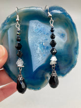 Load image into Gallery viewer, These shimmering black and silver glass beaded earrings feature a large black teardrop glass bead for added movement. This sophisticated and versatile accessory can be worn for an elegant evening look, brunch ensemble, wedding necklace, or minimalist style.  Measurements: 2 1/2” in length
