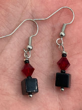 Load image into Gallery viewer, This eye-catching piece features two unconventional components: a large square-shaped black obsidian bead and a large, dark red glass bead. With the beautiful interplay of colors and shapes, these earrings are truly unique, yet at the same time, versatile enough to be paired with a range of styles.  Measurements: 1” in length 
