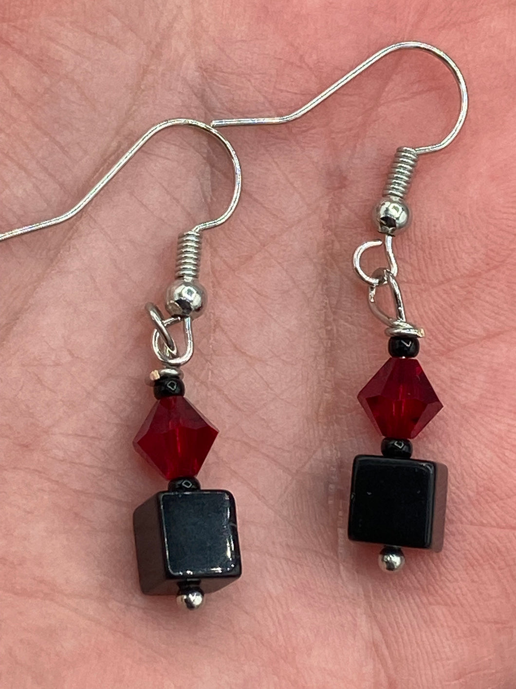 This eye-catching piece features two unconventional components: a large square-shaped black obsidian bead and a large, dark red glass bead. With the beautiful interplay of colors and shapes, these earrings are truly unique, yet at the same time, versatile enough to be paired with a range of styles.  Measurements: 1” in length 