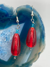 Load image into Gallery viewer, This eye-catching piece set of earrings consists of large fire engine red and tiny teal glass beads for a vibrant and bold look.  Measurements: 1 1/2” in length 
