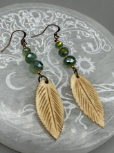 Load image into Gallery viewer, Single-stranded earring features bone carved leaf charm earrings with light mint faceted round glass beads.  Glass beads have a tint of dark green and gold shimmer. Antique Copper Plated Surgical Steel Hammered Long Ear-wire French Hook Earrings.  Measurements: 3” in length  
