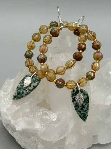Green-White Qinghai Green Jasper Stone Beaded Hoop Earrings provide a nature-inspired look that is perfect for any boho-chic style. These earrings feature natural green jasper stone triangle pendant with champagne mix melon Czech faceted round glass beads.  Glass beads have a tint of light champagne, amber, dark green and gold shimmer for subtle accent. Show off your bohemian look with these eye-catching hoops. Antique Copper Plated Surgical Steel Hammered Long Ear-wire French Hook Earrings. 