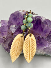 Load image into Gallery viewer, Single-stranded earring features bone carved leaf charm earrings with light mint faceted round glass beads.  Glass beads have a tint of dark green and gold shimmer. Antique Copper Plated Surgical Steel Hammered Long Ear-wire French Hook Earrings.  Measurements: 3” in length  
