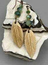Load image into Gallery viewer, Single-stranded earring features bone carved leaf charm earrings with light mint faceted round glass beads.  Glass beads have a tint of dark green and gold shimmer. Antique Copper Plated Surgical Steel Hammered Long Ear-wire French Hook Earrings.  Measurements: 3” in length  
