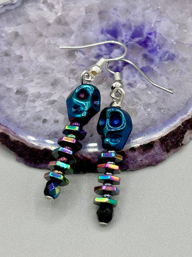 Spooky blue skull beads come with rainbow hematite spine earrings. These stylish skull earrings are perfect for adding a unique flair to any outfit. Whether you're looking for a Dia De Los Muertos accessory or simply looking to draw inspiration, these goth pieces perfectly capture the vampire goth, witchy, dark, Chingona Cabrona, Latina Chicana styles.   Measurements: 1 1/4” in length
