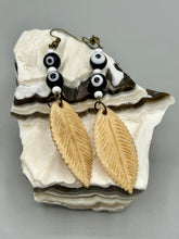 Load image into Gallery viewer, Single-stranded earring features bone carved leaf charm earrings with black and white eye-dot glass beads. Antique Copper Plated Surgical Steel Hammered Long Ear-wire French Hook Earrings.  Measurements: 3” in length  
