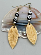 Load image into Gallery viewer, Single-stranded earring features bone carved leaf charm earrings with black and white eye-dot glass beads. Antique Copper Plated Surgical Steel Hammered Long Ear-wire French Hook Earrings.  Measurements: 3” in length  
