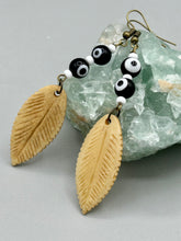 Load image into Gallery viewer, Single-stranded earring features bone carved leaf charm earrings with black and white eye-dot glass beads. Antique Copper Plated Surgical Steel Hammered Long Ear-wire French Hook Earrings.  Measurements: 3” in length  
