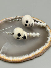 Load image into Gallery viewer, Peruvian off white ceramic skull beads come with spine earrings. These stylish skull earrings are perfect for adding a unique flair to any outfit. Whether you&#39;re looking for a Dia De Los Muertos accessory or simply looking to draw inspiration, these goth pieces perfectly capture the vampire goth, witchy, dark, Chingona Cabrona, Latina Chicana styles.   Measurements: 1 1/4” in length
