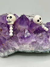 Load image into Gallery viewer, Peruvian off white ceramic skull beads come with spine earrings. These stylish skull earrings are perfect for adding a unique flair to any outfit. Whether you&#39;re looking for a Dia De Los Muertos accessory or simply looking to draw inspiration, these goth pieces perfectly capture the vampire goth, witchy, dark, Chingona Cabrona, Latina Chicana styles.   Measurements: 1 1/4” in length
