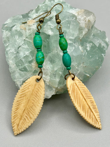 Single-stranded earring features bone carved leaf charm earrings with bright green magnesite stone beads. Antique antique brass plated steel ear-wire French Hook Earrings.  Measurements: 3” in length   