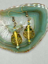 Load image into Gallery viewer, This pair of earrings features a dark amber and green tone, pressed glass leaf charm in an iridescent finish that gives off subtle hues of gold. Complemented with light ming green glass beaded earrings, this set is sure to sparkle.   Measurements: 1 1/4&quot; length
