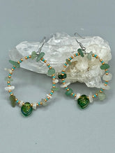 Load image into Gallery viewer, Natural aventurine stone chips, turquoise, and gold glass beads are strung together to form these stylish hoop earrings. The dark green pressed glass leaf charm complements the design, creating an iridescent, shimmery finish with subtle hues of gold, purple, blue, and pink.  Measurements: 2&quot; length
