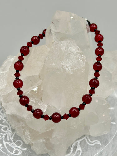 Single-strand dark red round glass beaded bracelet with dark red faceted crystals. Crafted with metal wire and fastened with a lobster claw clasp.  Measurements:   Bracelet: 8