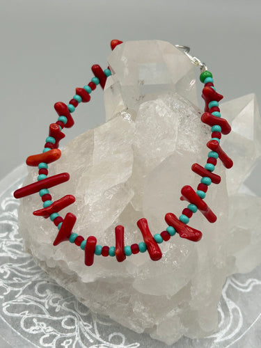 This distinctive Southwestern Style bracelet boasts a captivating combination of large red coral and blue-green turquoise glass beads for a visual impact. Crafted with metal wire and fastened with a lobster claw clasp, this bracelet is sure to command attention.  Measurements:  Bracelet: 8
