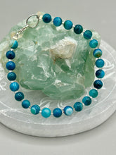 Load image into Gallery viewer, Nature inspired single-strand sea blue stripped agate round stone beaded with silver glass beaded bracelet. Crafted with metal wire and fastened with a lobster claw clasp.  Measurements:  Bracelet: 8&quot; in length   
