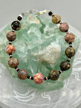 Load image into Gallery viewer, Nature inspired single-strand leopard jasper round stone beads with gold and black glass beaded bracelet. Leopard jasper stone has an array on neutral earth tones including soft pink, salmon, and gray tones. Crafted with metal wire and fastened with a lobster claw clasp.  Measurements:   Bracelet: 7 1/2&quot; in length   
