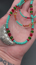 Load and play video in Gallery viewer, Southwestern Style Inspired Adjustable Choker Beaded Necklace, Turquoise And Red Glass Beads, Wide Silver Plated Tribal Pattern Pendant
