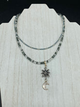 Load image into Gallery viewer, This Dainty Smiling Crescent Moon And Star Silver And Gray Choker Style Necklace features a variety of shimmering glass beads in light silver and gray tones. Varying in shape and size, these beads lend a unique and witchy celestial vibe to the necklace.  Measurements:  Necklace is 15 3/4”adjustable up to 18&quot;
