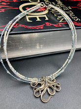 Load image into Gallery viewer, This stylish necklace features a silver plated metal octopus pendant and vibrant iridescent and silver-gray glass beads of various sizes. The Steampunk-inspired design provides a textured, patterned and voluminous look perfect for any dark goth or witchy aesthetic. Measurements:  Necklace measures 15 1/2” adjustable up to 17” in length
