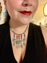 Load image into Gallery viewer, This two-strand adjustable necklace features a culturally inspired design with vibrant green turquoise, bright red, orange, green and gold glass beads, accompanied by silver plated feather charms that create a unique sense of motion. An ideal accessory for summer styles, this native tribal pattern necklace and matching earrings set will perfectly complete any ensemble.  Measurements:  Necklace: 15 3/4” adjustable up to 18" in length
