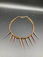 Load image into Gallery viewer, A copper-toned, adjustable Steampunk-style glass beaded necklace is detailed with sharp-drop metal plated hanging beads. Bright orange rectangular tube beads mix with other shapes for an eye-catching effect, while double-hole flat matte copper-toned beads provide a collar finish which makes this piece drape elegantly across the neck. A bold and sophisticated accessory.
