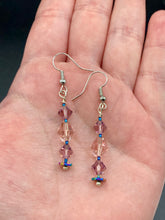 Load image into Gallery viewer, These dainty glass beaded earrings in soft pink and purple, featuring rainbow hematite beads, are perfect for summer ensembles and boho chic looks. An ideal accessory for nature lovers, these earrings will enhance any style.  Measurements: 1 1/2” in length

