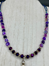 Load image into Gallery viewer, This double-stranded necklace is adorned with a large agate stone displaying a spectrum of purple shades, from light sheer to deep dark tones. The combination of purple agate and multi-colored glass beads makes this pendant a stunning addition to any summer look.  Measurements:  Necklace is 17” in length 
