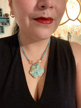 Load image into Gallery viewer, This vibrant and striking double strand necklace features a combination of glass beads in blue and green shades of turquoise, gold and champagne. The two delicate strands are accented with a gold-tone flower-shaped bead, a howlite stone chip dyed in turquoise, and shimmery, cross-faceted champagne-colored glass beads to complete the dramatic look.  Measurements:   Necklace is 17” and can be adjusted up to 19"
