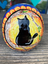 Load image into Gallery viewer, I wanted to create a Dia De Los Muertos skull that represented the eternal love for a special kitty cat in your life. Black cat silhouette is sitting admiring the sun going down. This Day Of The Dead ceramic skull art was created for the cat lovers who adore their sweet kitty. Measurements: H 4” x W 4” x D 5 1/2”
