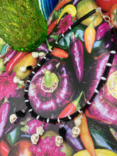 Load image into Gallery viewer, This sophisticated, yet dark-themed necklace utilizes small howlite skull beads along with black and white quartize floral beads to capture the iconic floral crown of Frida Kahlo. This Chingona, Cabrona, Latina Chicana, Goth, Vampire Goth, Dark Witchy Style jewelry can be used to inspire and to celebrate Dia de los Muertos. Equally suitable for dressy and casual outfits, the piece gives a unique edge to any look.
