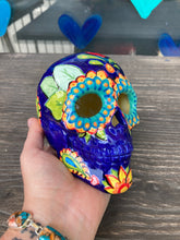Load image into Gallery viewer, I wanted to create a skully that represented the eternal love for a special kitty cat in your life. Dark royal blue ceramic sugar skull with black cat silhouette is sitting admiring the sun going down. This Day Of The Dead ceramic skull art was created for the cat lovers who adore their sweet kitty. Measurements: H 4” x W 4” x D 5 1/2”
