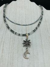 Load image into Gallery viewer, This Dainty Smiling Crescent Moon And Star Silver And Gray Choker Style Necklace features a variety of shimmering glass beads in light silver and gray tones. Varying in shape and size, these beads lend a unique and witchy celestial vibe to the necklace.  Measurements:  Necklace is 15 3/4”adjustable up to 18&quot;
