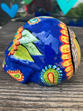 Load image into Gallery viewer, I wanted to create a Dia De Los Muertos skull that represented the eternal love for a special kitty cat in your life. Black cat silhouette is sitting admiring the sun going down. This Day Of The Dead ceramic skull art was created for the cat lovers who adore their sweet kitty. Measurements: H 4” x W 4” x D 5 1/2”
