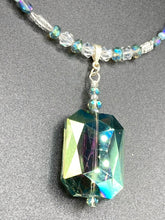 Load image into Gallery viewer, This gorgeous, Bohemian-style necklace features a shimmery aqua blue and gold-toned glass beaded design, with a large, faceted rectangular pendant adding dramatic flair. The vibrant and eye-catching colors make it the perfect way to add a pop of color to any ensemble and the draping style will give you a look that is both bold and elegant.  Measurements:    Necklace is 17” - adjustable to 18&quot;, pendant is 2 1/4”
