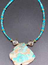 Load image into Gallery viewer, This vibrant and striking double strand necklace features a combination of glass beads in blue and green shades of turquoise, gold and champagne. The two delicate strands are accented with a gold-tone flower-shaped bead, a howlite stone chip dyed in turquoise, and shimmery, cross-faceted champagne-colored glass beads to complete the dramatic look.  Measurements:   Necklace is 17” and can be adjusted up to 19"
