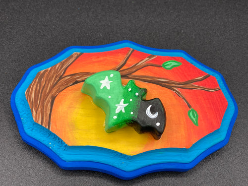 This unique Starry Night Mini Bat Wall Art Decor is hand sculpted and painted in vivid hues to offer an eye-catching decoration for your living space. The bat is painted in a gradient of light green to dark green to black, and is complemented by white stars and a crescent moon. The wood frame is painted in yellow, orange and red for a stunning sundown effect, with a royal blue edge for added contrast.