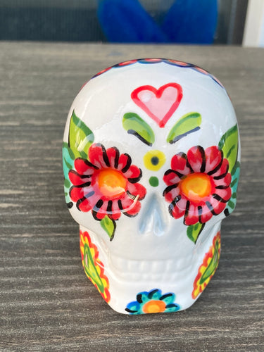 Inspired by nature, ceramic skull is full of vibrant colors and intricate details. The primary color is white with a black cat silhouette and multi-color floral motifs, along with hearts and leaves and lively colorful accents around the entire skull.  Mini skull represented the eternal love for a special kitty cat in your life. Black cat silhouette is sitting on a tree branch admiring the starry night sky. Art created for all the cat lovers who adore their sweet kitty.  Measurements: H 2 3/4” x W 2” x D 2”