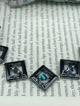 Load image into Gallery viewer, This two-strand necklace, crafted from aqua-blue and silver toned glass beads, is a stunning statement piece. The addition of faceted triangle-shaped glass beads tucked between hematite square beads adds an exquisite and unique flair. The necklace gracefully drapes around the neck, bringing an air of bold and elegant flair to any ensemble it complements. 15” in length, can be extended up to 17"
