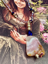 Load image into Gallery viewer, A soft dusty rose agate pendant is accompanied by shimmery beads of dusty rose, blue, dark pink, and gold. Adorned with large deep purple glass beads with a hint of gold shimmer, this stunning necklace set evokes a rose garden.  Measurements:  Necklace is 15” adjustable to 18&quot;
