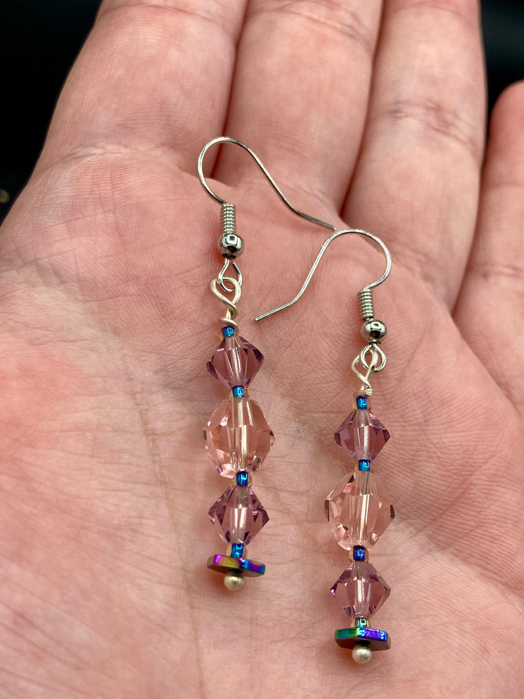 These dainty glass beaded earrings in soft pink and purple, featuring rainbow hematite beads, are perfect for summer ensembles and boho chic looks. An ideal accessory for nature lovers, these earrings will enhance any style.  Measurements: 1 1/2” in length