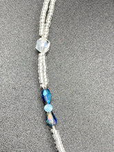 Load image into Gallery viewer, This gorgeous, Bohemian-style necklace features a shimmery aqua blue and gold-toned glass beaded design, with a large, faceted rectangular pendant adding dramatic flair. The vibrant and eye-catching colors make it the perfect way to add a pop of color to any ensemble and the draping style will give you a look that is both bold and elegant.  Measurements:    Necklace is 17” - adjustable to 18&quot;, pendant is 2 1/4”
