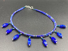 Load image into Gallery viewer, This Vibrant Royal Blue Glass Beaded Choker Necklace features two adjustable strands of deep blue beads with purple hues. The Bohemian style jewelry includes a mixture of rectangular-shaped blue, purple, and silver glass beads, which come together to create an eye-catching and elegant look. Perfect for any outfit, this draping necklace will add a vibrant and bold touch to your style.  Measurements:    Necklace is 14 3/4” in length, can be adjusted up to 16"
