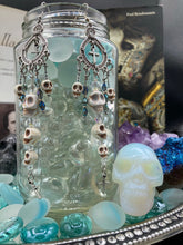 Load image into Gallery viewer, Day of The Dead, La Catrina Dia De Los Muertos Aretes, Pastel Goth Jewelry, Dangling Skulls Silver Cross Beaded Chandelier Style Earrings
