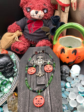 Load image into Gallery viewer, This 25mm bright orange pumpkin bead pendant necklace is a perfect complement to any Halloween ensemble. It is additionally enhanced by shimmery glass beads in classic Halloween hues, such as black, dark green, and light green.  Measurements: Necklace is 19”
