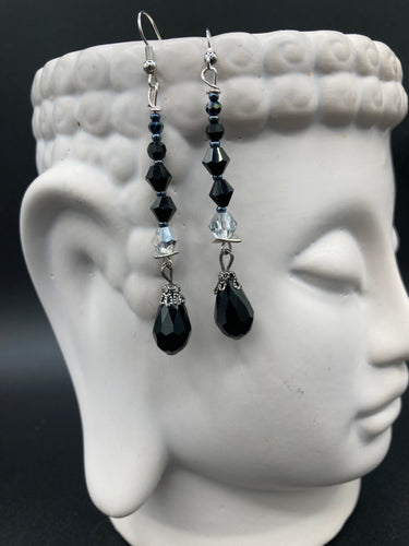 These shimmering black and silver glass beaded earrings feature a large black teardrop glass bead for added movement. This sophisticated and versatile accessory can be worn for an elegant evening look, brunch ensemble, wedding necklace, or minimalist style.  Measurements: 2 1/2” in length